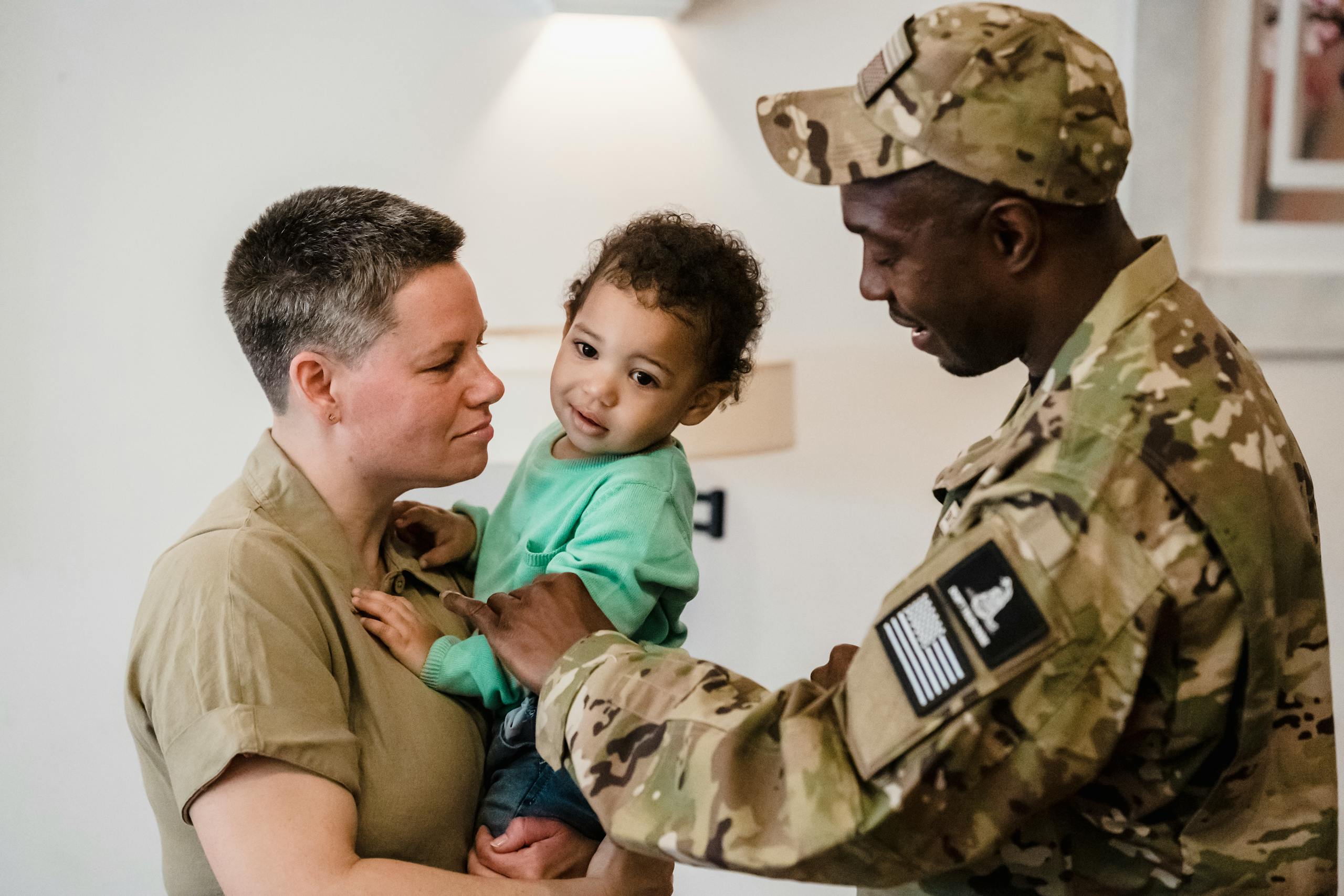 A touching moment of a military father reuniting with his family indoors.